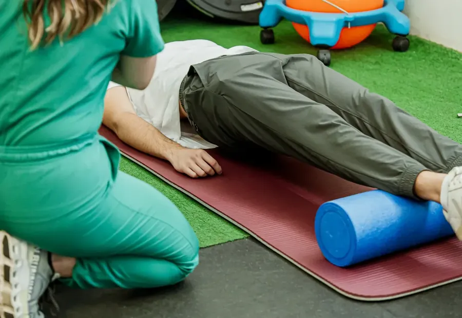Fisioterapeuta trabajando con un paciente en colchoneta