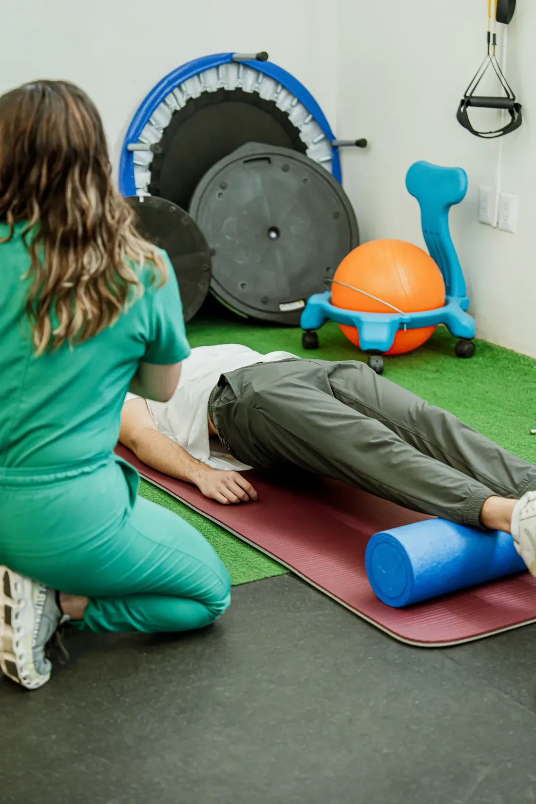 Fisioterapeuta trabajando con un paciente en colchoneta